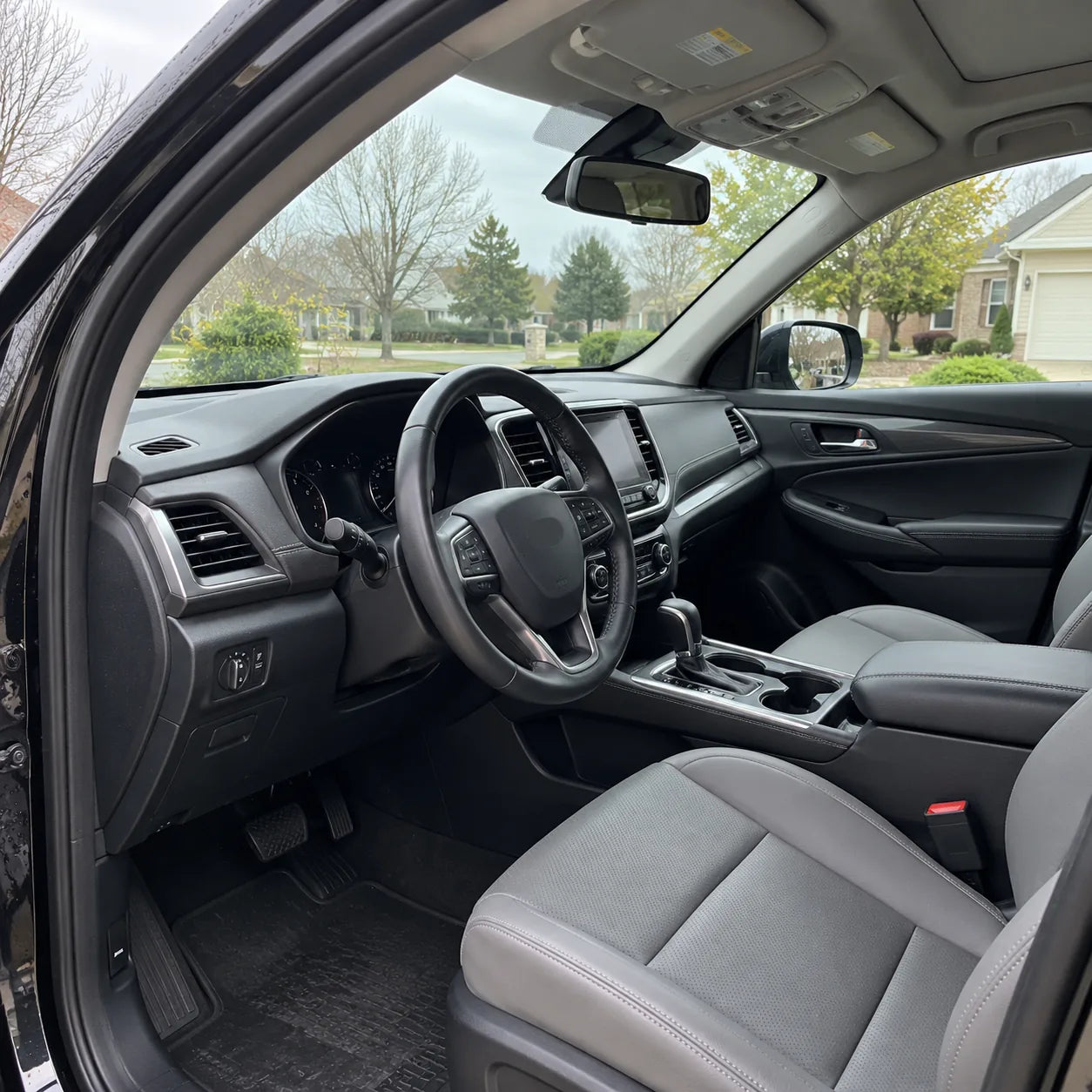 Clean SUV interior and windshield viewed through the open driver door
