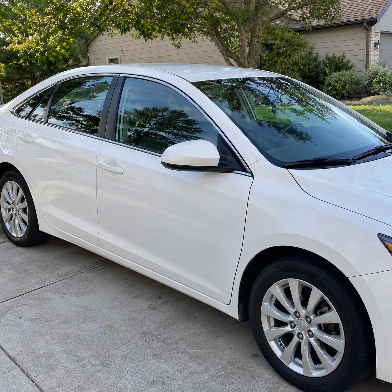 Plate-free white sedan with clear windshield glass